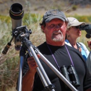 Rich Stallcup holding a spotting scope on a tripod