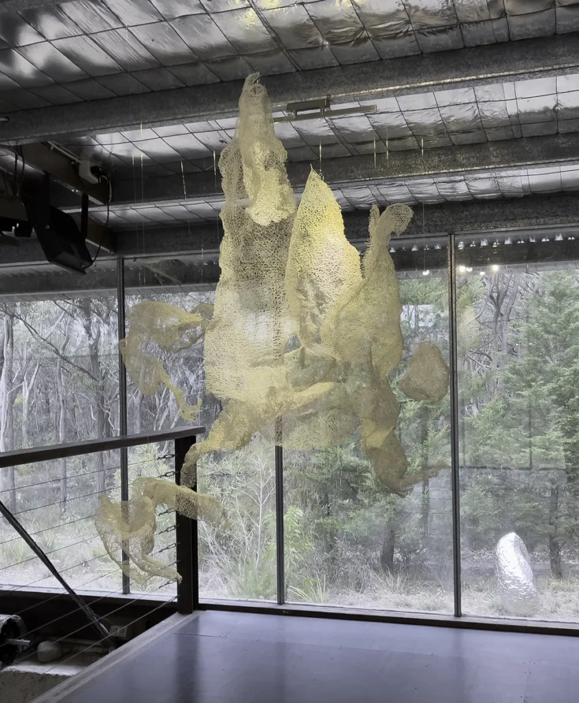 An ethereal, light-weight sculpture suspended in the air in a gallery.